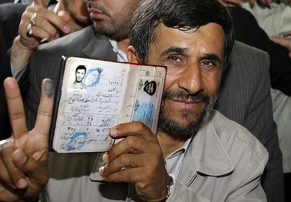 President Mahmoud Ahmadinejad holds his passport while flashing the victory sign after casting his ballot for the Iranian presidential election in Tehran.