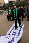 Hamas leader Mahmoud al-Zahar walk on an Israeli flag reading in Arabic 