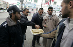 Palestinians distribute desserts celebrating the attack at the Jewish settlement of Itmar near Nablus in Rafah on March 12, 2011. A Palestinian infiltrated Itamar early Saturday and killed five people, the Israeli military said. Photo by Abed Rahim Khatib