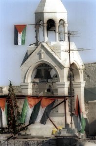 Palästinensische Nationalflaggen, ein Weihnachtsbaum und unten rechts ein Modell des Jerusalemer Felsendoms, dem wichtigsten Symbol des Islam auf dem Dach der Geburtsbasilika von Bethlhem, wo der Tradition gemäß Jesus geboren wurde. Bethelhem.